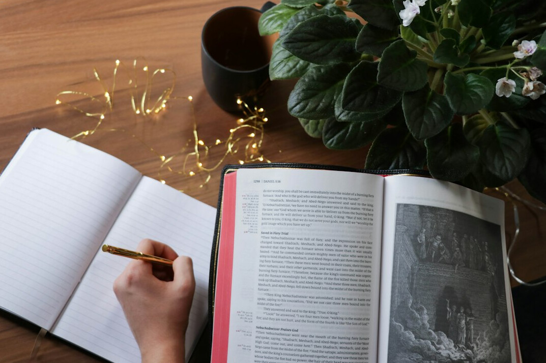 Person journaling and reading for self growth at a desk